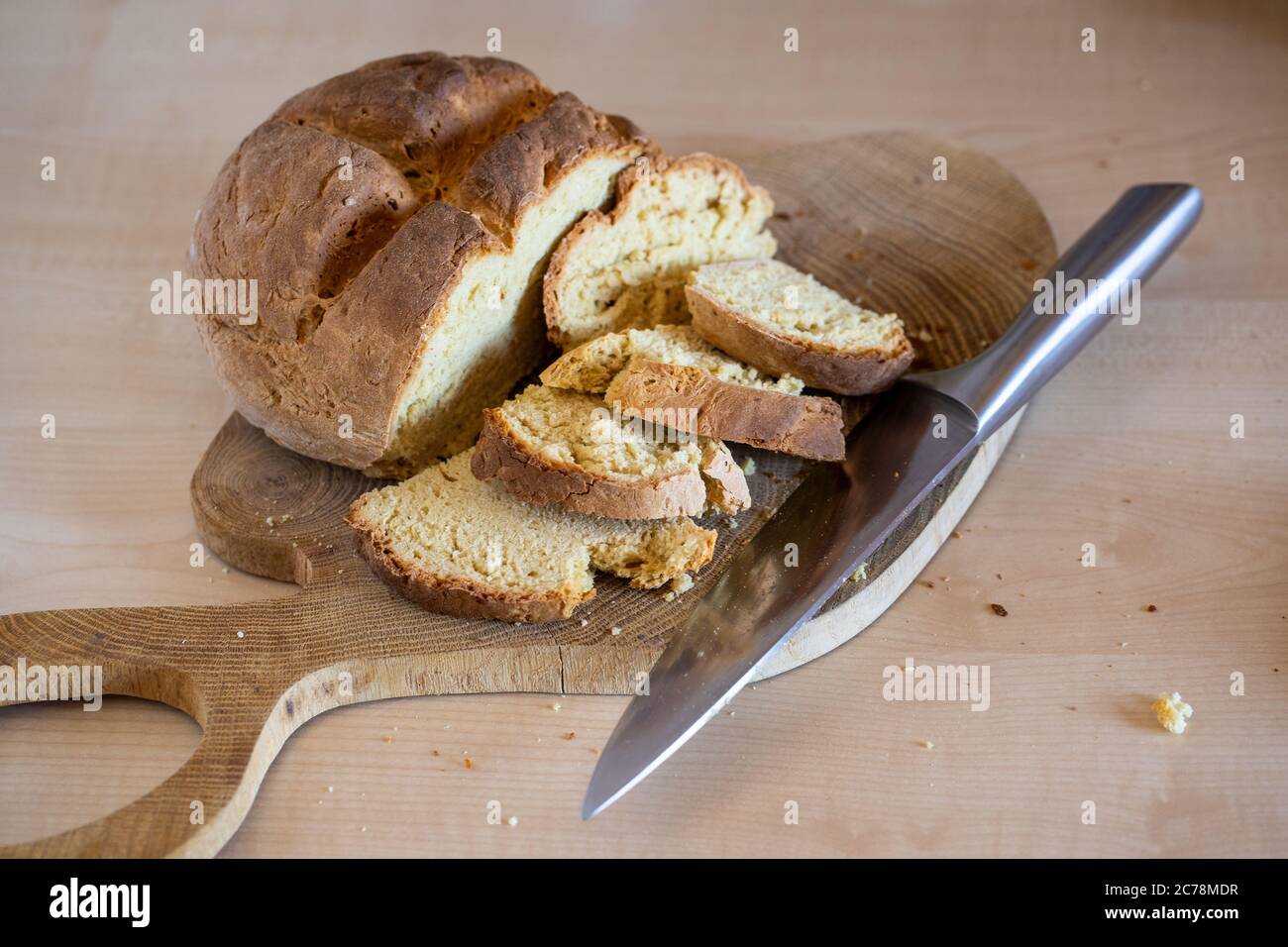 Pain de soda irlandais fraîchement cuit en tranches avec un gros couteau sur le côté. Une pâtisserie saine, maison et délicieuse. Banque D'Images