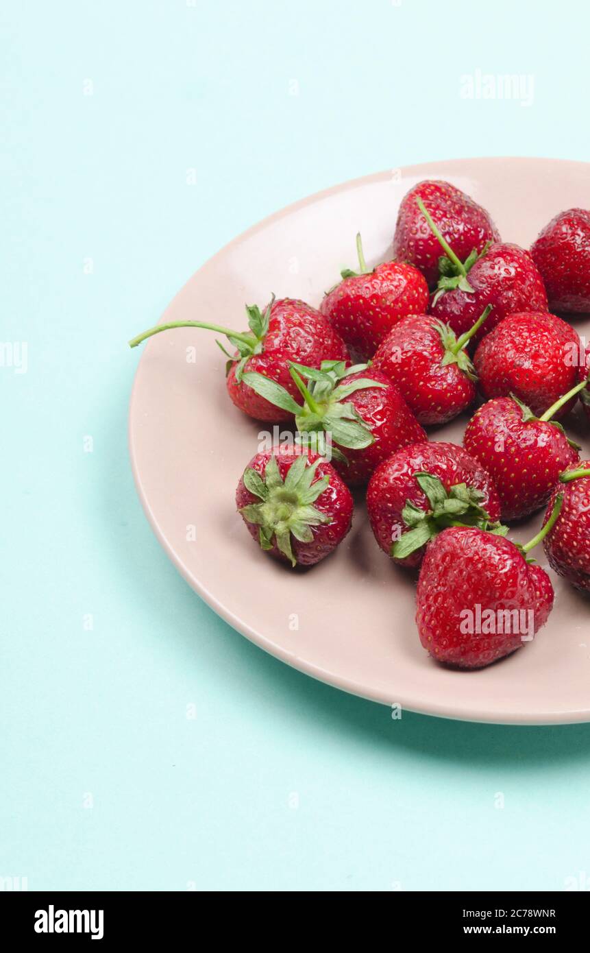 fraises rouges fraîches sur plaque pastel sur fond blanc Banque D'Images