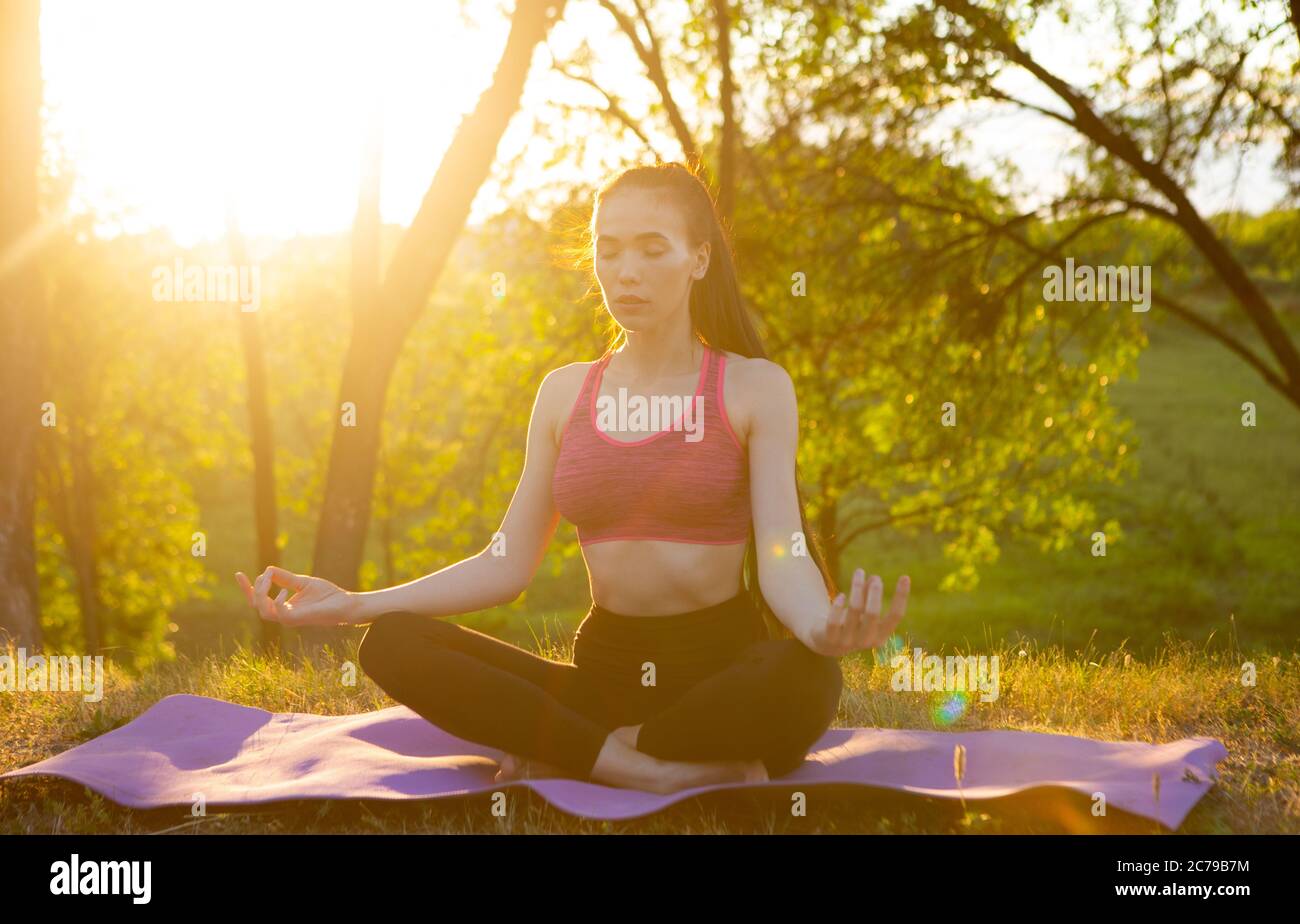 La fille pratique le yoga dans l'air frais, rempli d'énergie pour la journée. Banque D'Images