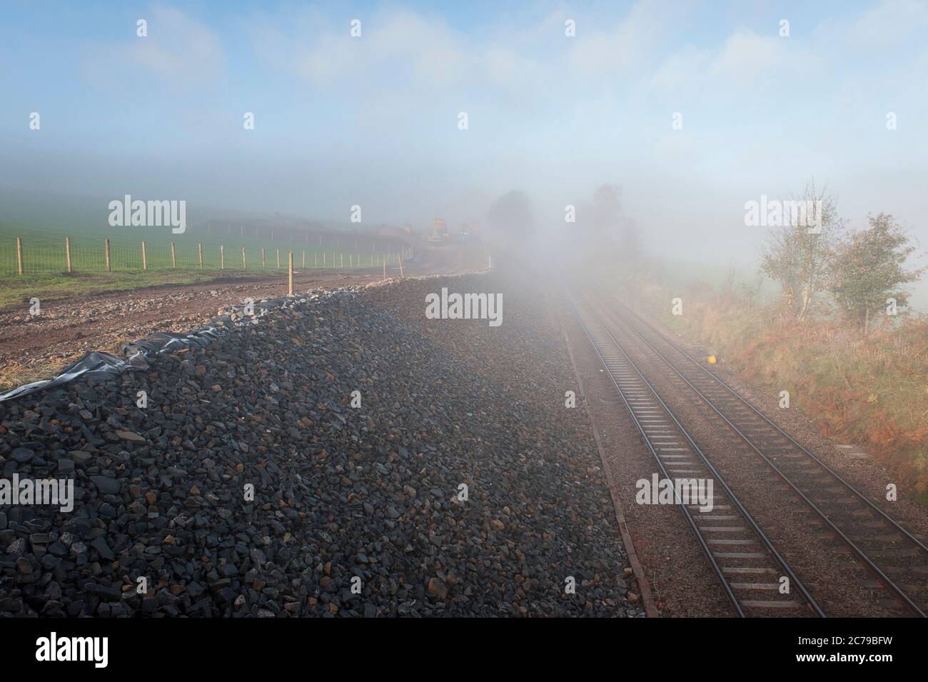 Piste ferroviaire en une coupure par un jour brumeux en Angleterre, au Royaume-Uni. Banque D'Images