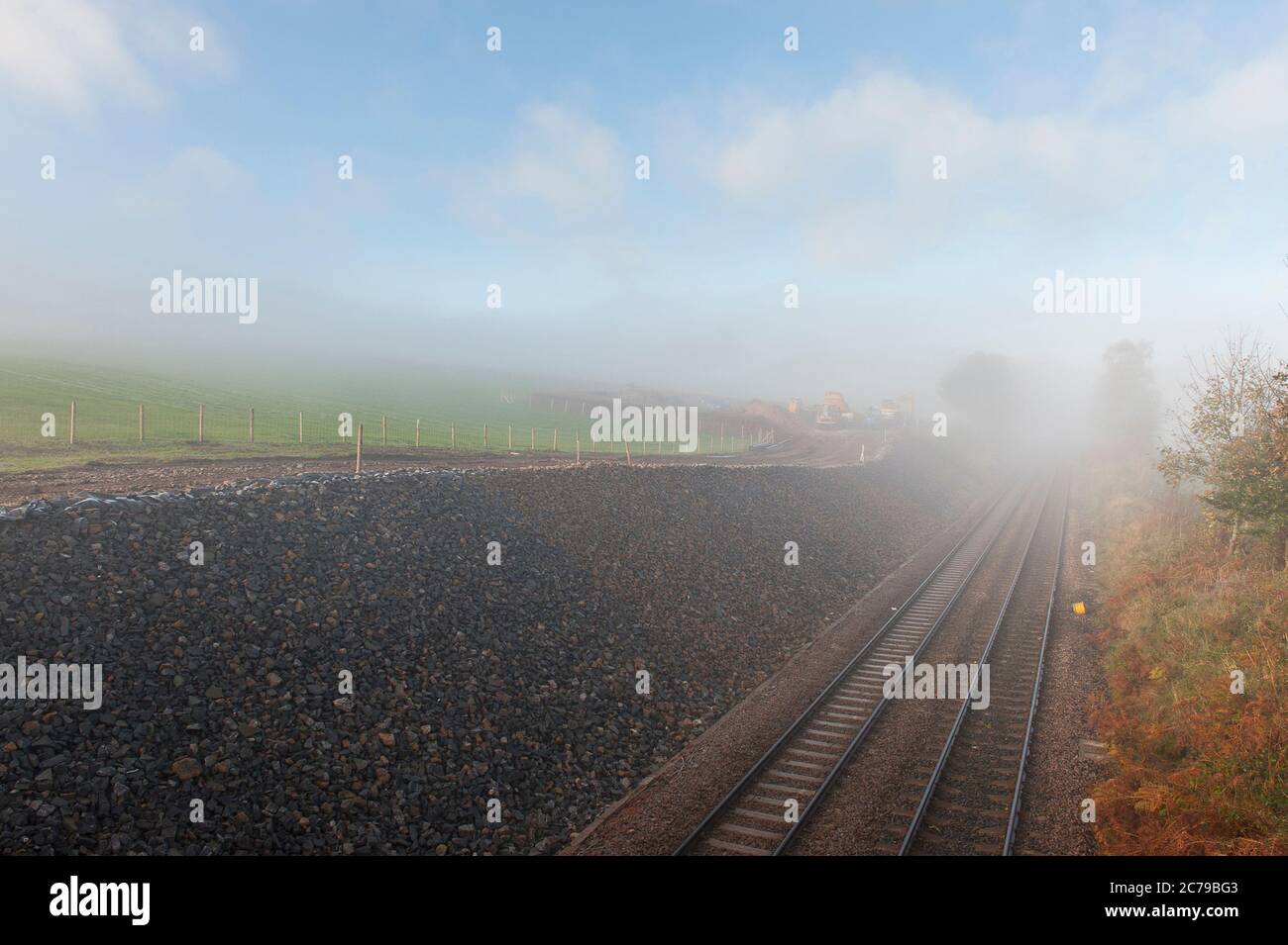 Piste ferroviaire en une coupure par un jour brumeux en Angleterre, au Royaume-Uni. Banque D'Images