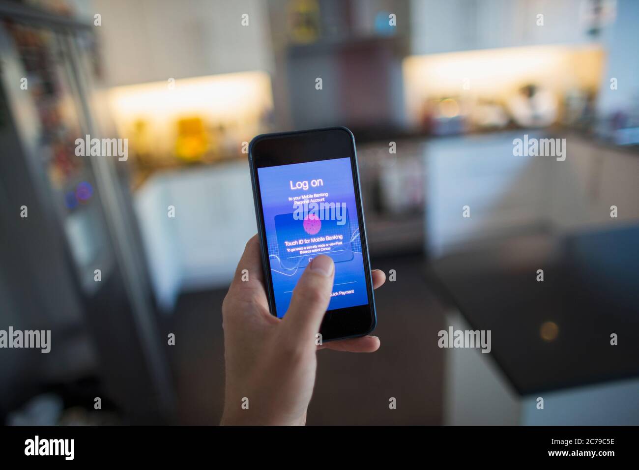 POV Man utilisant l'ID de touche sur le smartphone dans la cuisine Banque D'Images