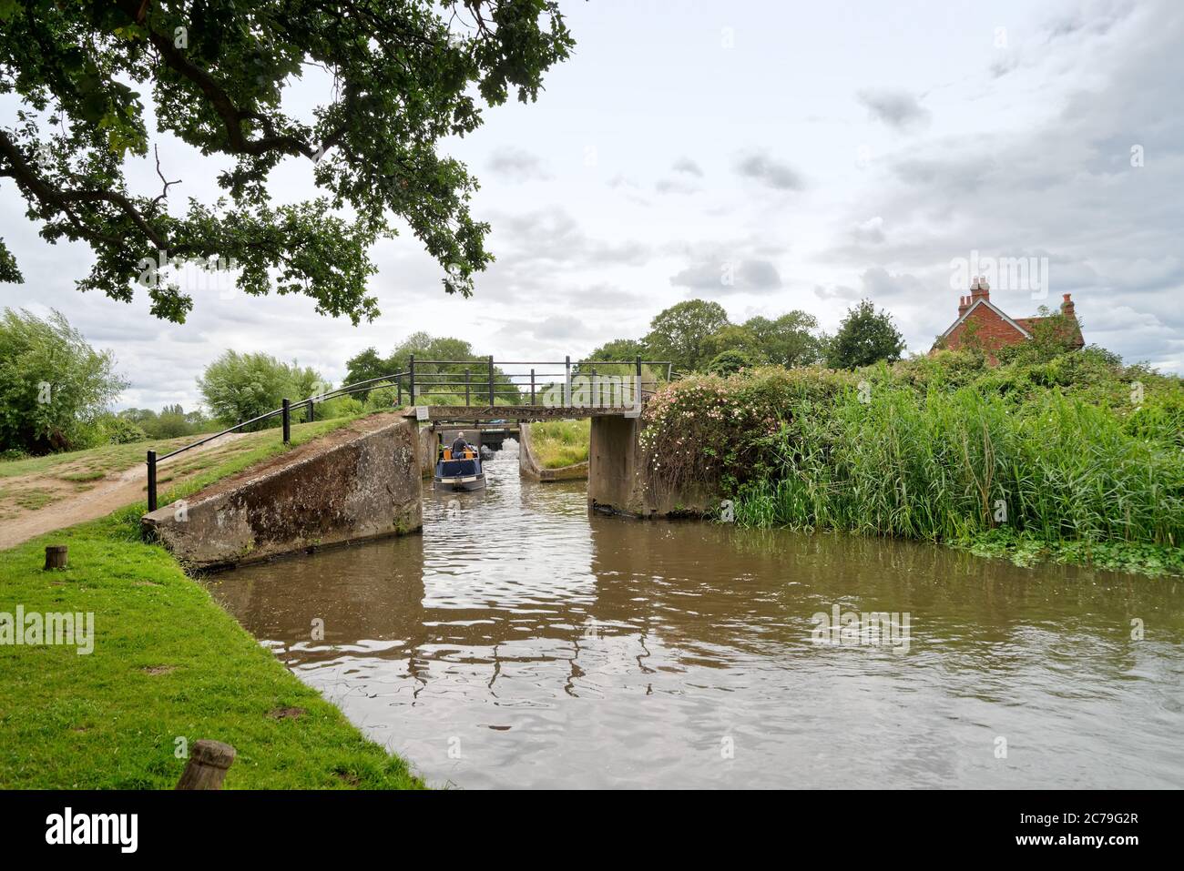 Un petit bateau négociant l'écluse de Papercourt sur la rivière Wey navigation près de Ripley Surrey Angleterre Royaume-Uni Banque D'Images