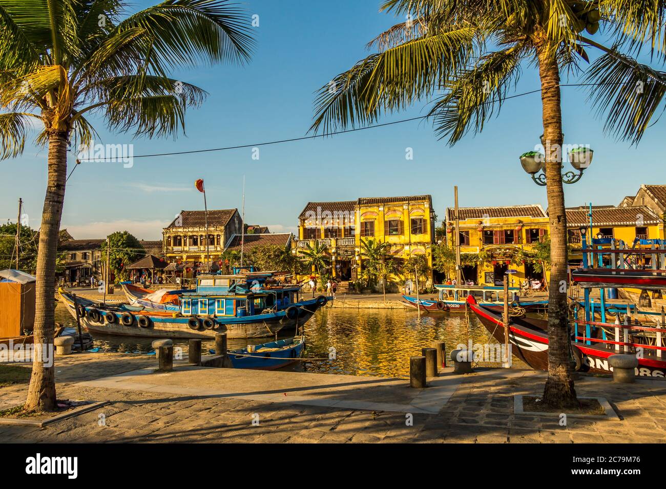 Vue sur la rivière depuis la rive sud de Hoi an Vietnam, avec palmiers et bateaux au premier plan Banque D'Images