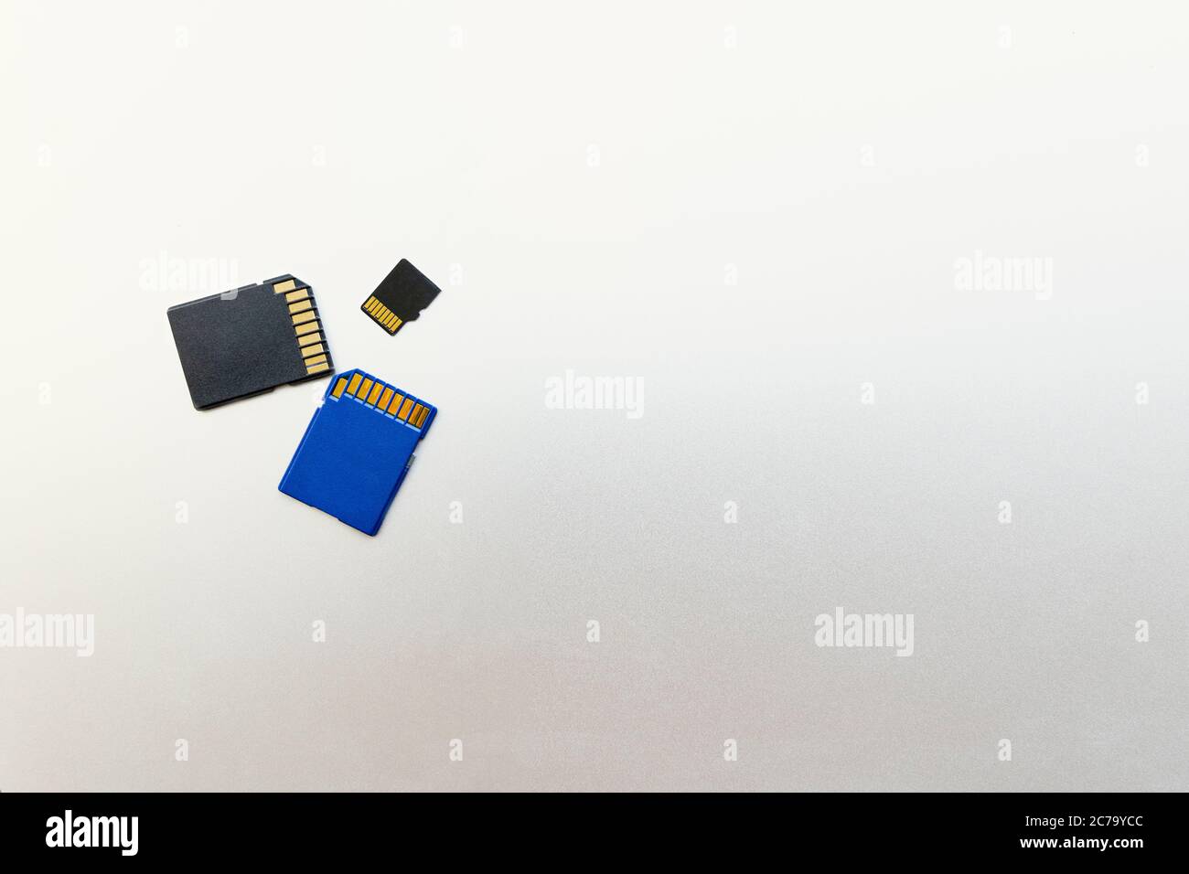 Trois cartes SD ou cartes mémoire pour appareils photo et appareils numériques et, sur une surface métallique grise, espace de copie pour le texte Banque D'Images
