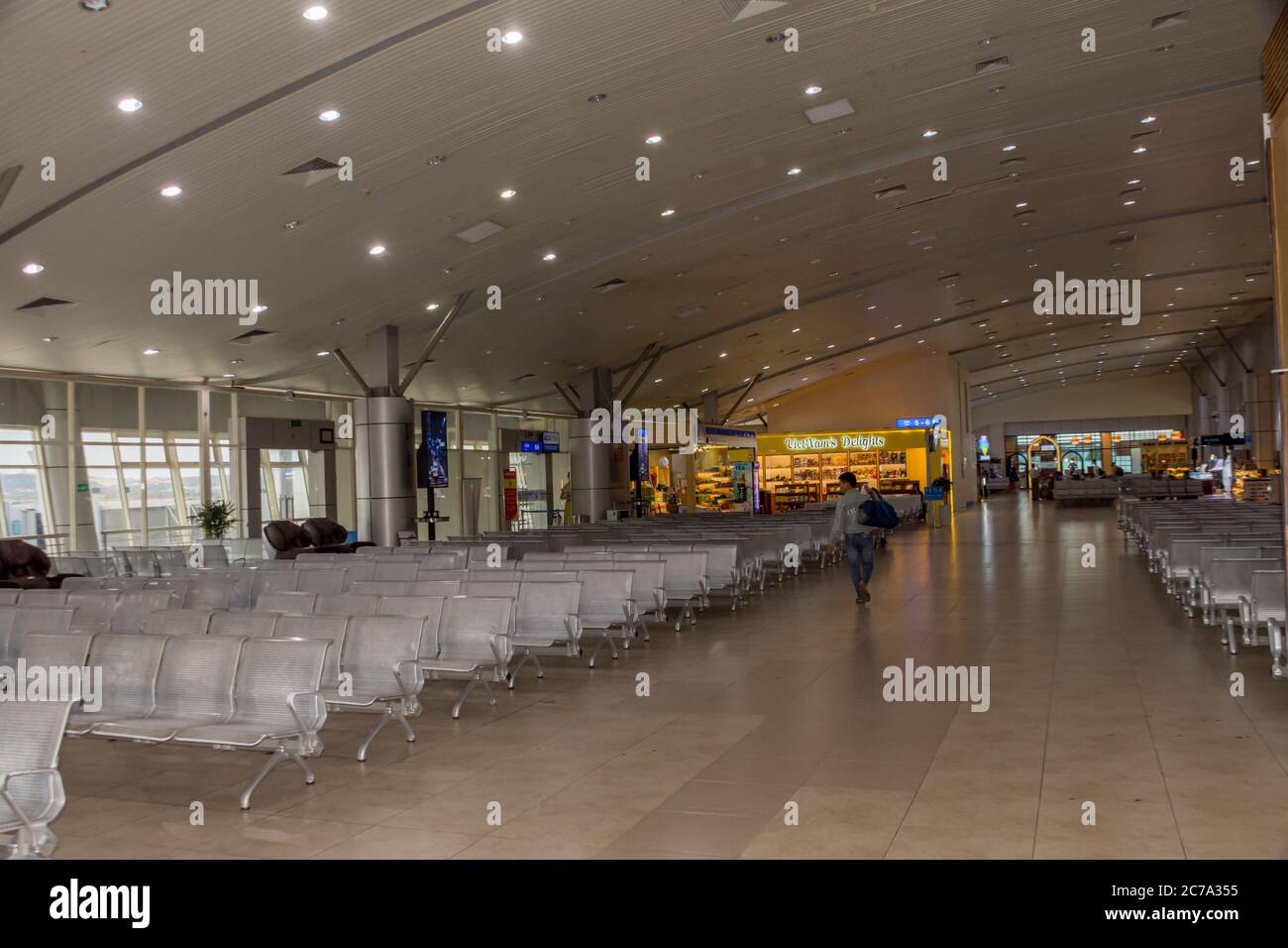 Un passager traverse un terminal d'aéroport international vide pour montrer l'impact de Covid 19 sur les vols alors que les aéroports commencent à ouvrir de nouveau les gens de vol à la maison. Banque D'Images