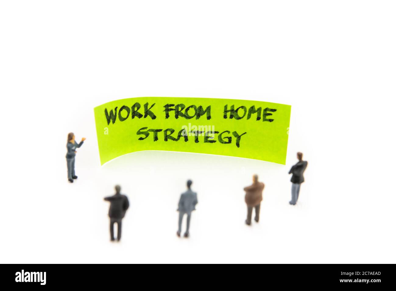 Rencontre avec des figurines miniatures posées comme des hommes d'affaires se tenant autour de post-it note avec travail de la stratégie de message sur fond blanc, minim Banque D'Images
