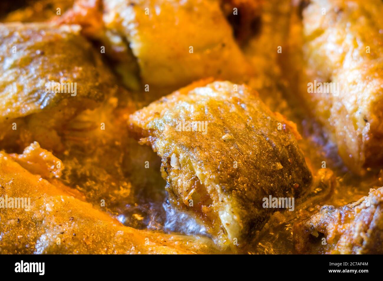 Morceaux de poisson navaga en pâte, frits dans l'huile dans une casserole. Banque D'Images