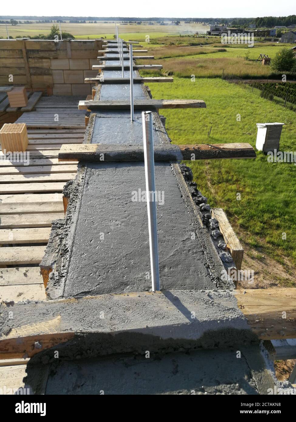 Vis métalliques insérées dans le béton humide pour la fixation sur le toit d'une maison individuelle Banque D'Images