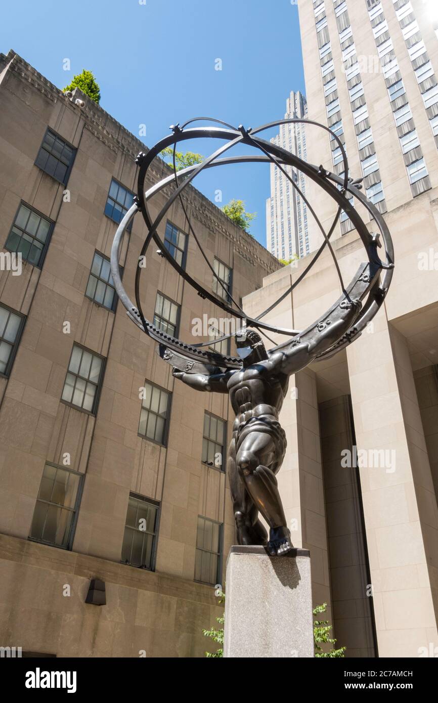 L'ancien Titan grec Atlas tenant les cieux Bronze Armillary sphère Sculpture au Rockefeller Center portant un masque de visage dû à COVID-19, NYC, USA Banque D'Images