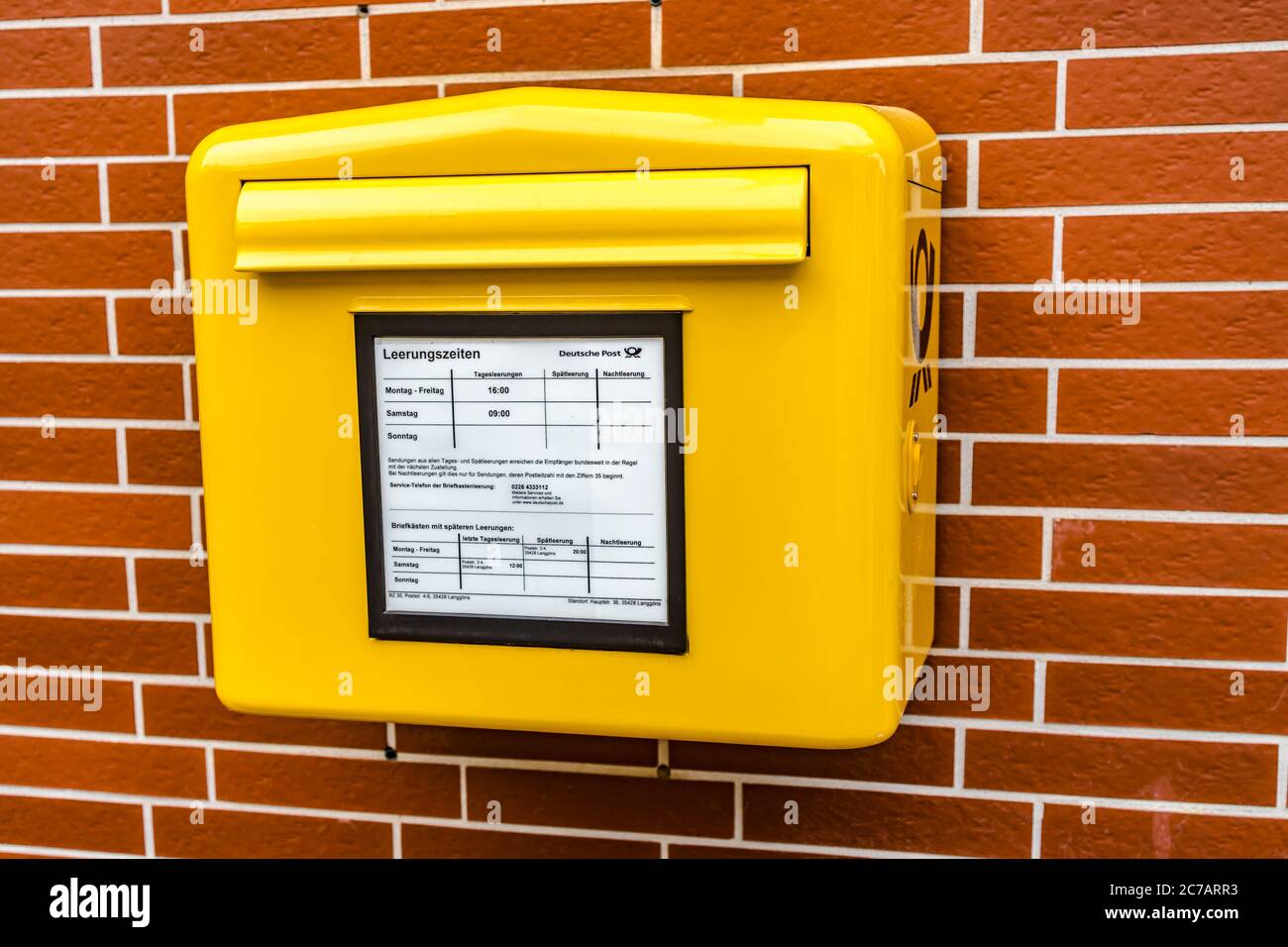 Oberkleen, Allemagne - 2020-05-16 , boîte aux lettres jaune du Bundespost allemand suspendue sur une façade de maison en allemagne. Banque D'Images