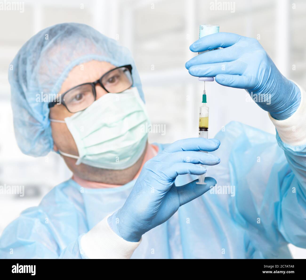 Le médecin prend le médicament d'une bouteille à une injection, se concentre sur les mains, visage flou. Scientifique tenant une seringue et un vaccin. Banque D'Images