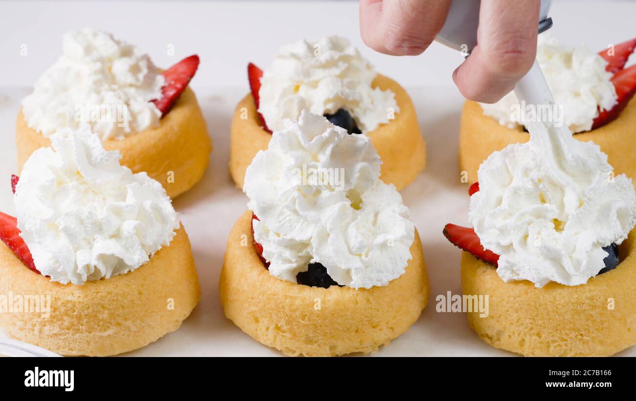Gateaux De Biscuits Aux Baies Fraiches Au Chocolat Et A La Creme Fouettee Femme Preparant Le Dessert Mini Tasses De Biscuits Avec Fraises Et Bleuets C Photo Stock Alamy