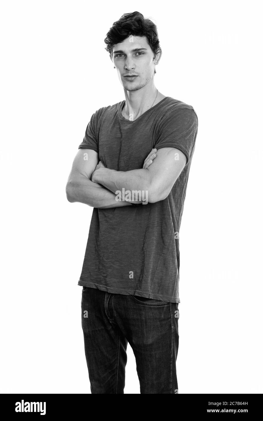 Studio shot of young man standing with arms crossed Banque D'Images Studio shot of young man standing with arms crossed Banque D'Images