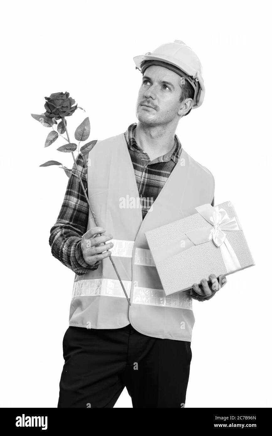 Homme de construction attentionné tenant la rose rouge et boîte cadeau prêt pour la Saint-Valentin Banque D'Images