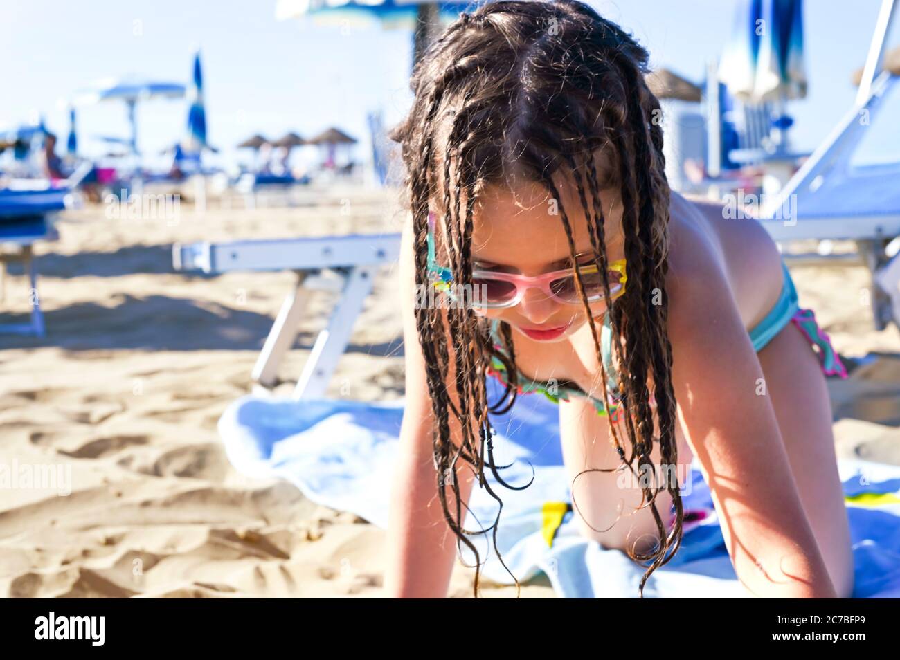 Une Petite Fille En Maillot De Bain Joue Sur La Plage Sourit Enfant De 7 Ans Sur La Plage Equipee De L Italie Le Concept D Ete Vacances En Famille Au Bord De La