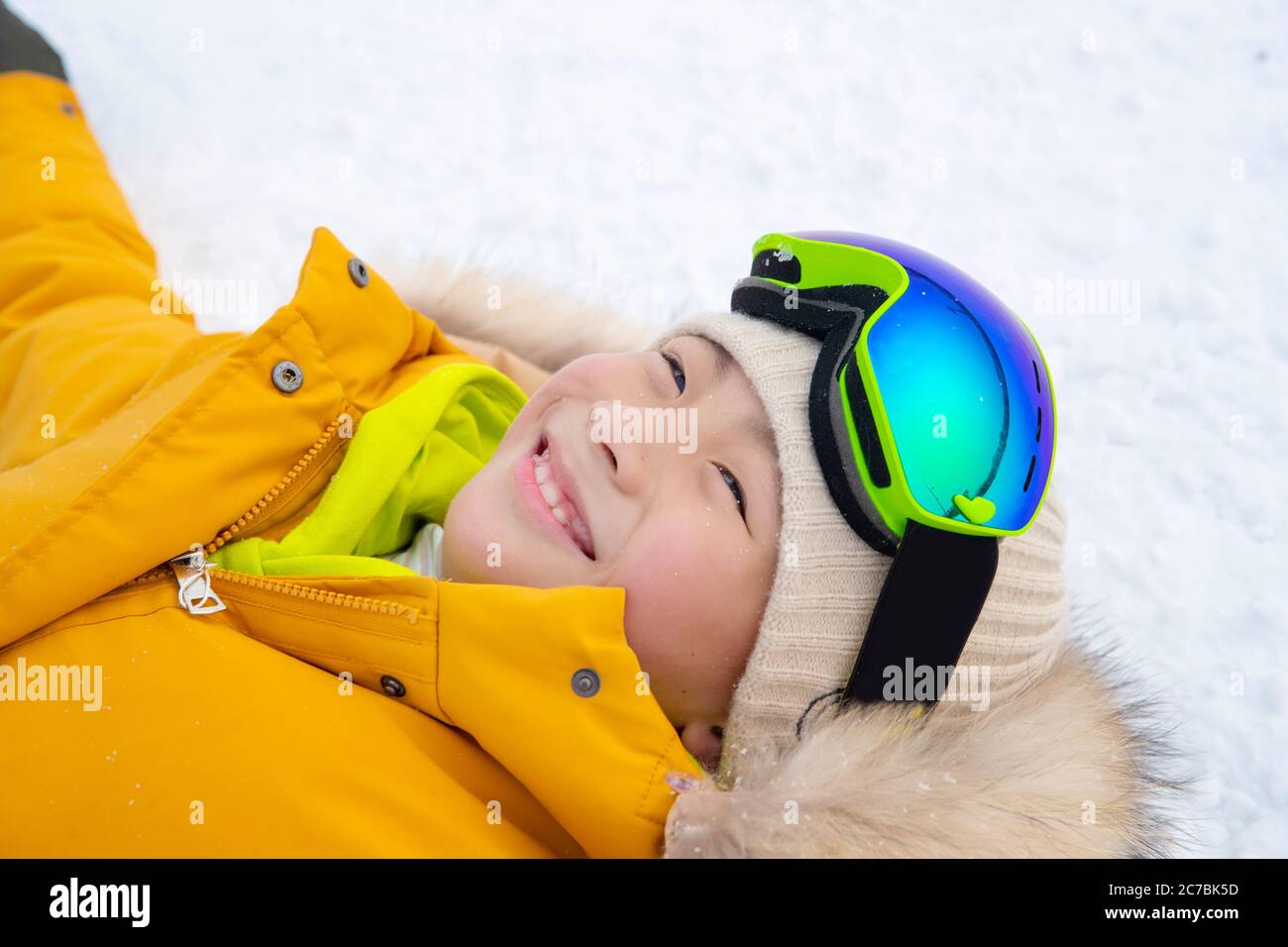Joyeux garçon couché dans la neige Banque D'Images