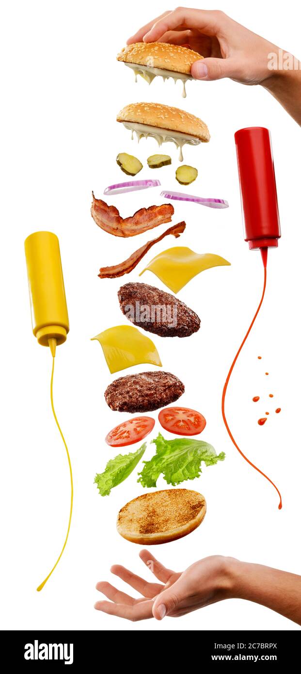 Kit d'ingrédients volants de hamburger et les mains de l'homme isolées sur blanc Banque D'Images