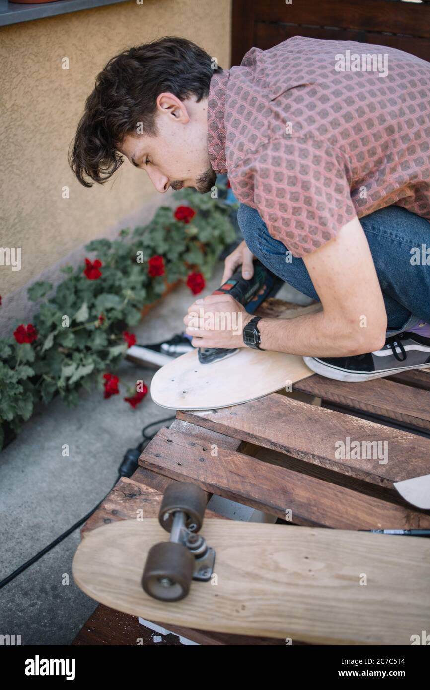 Homme concentré lissage de bois de planche à ponder Banque D'Images