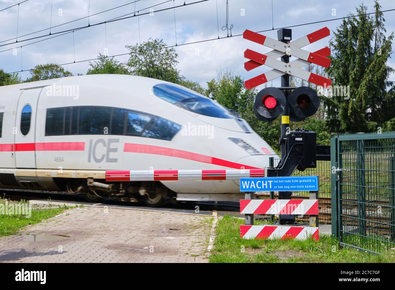 Bennekom-pays-Bas,Juli 11,2020:train ICE allemand passant un passage de chemin de fer fermé avec barrières fermées feux rouges clignotants. Message d'avertissement attendre Banque D'Images