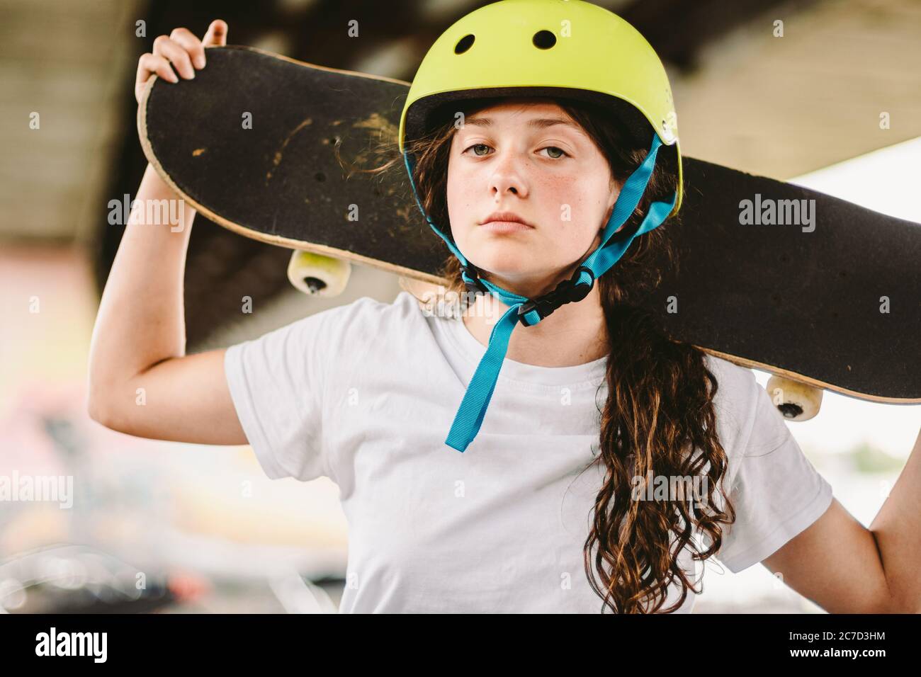 Une adolescente en casque et des vêtements élégants posant sur une rampe à  demi-pipe, un parc de skate extérieur. Magnifique skate modèle femme enfant  avec planche à roulettes Photo Stock - Alamy