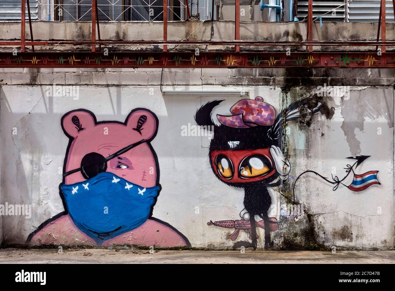 Masque visage Covid 19, ancienne décoration murale à peeling mise à jour à l'image Graffiti amusante avec ours Teddy portant le masque facial coronavirus et un ami perplexe. Banque D'Images