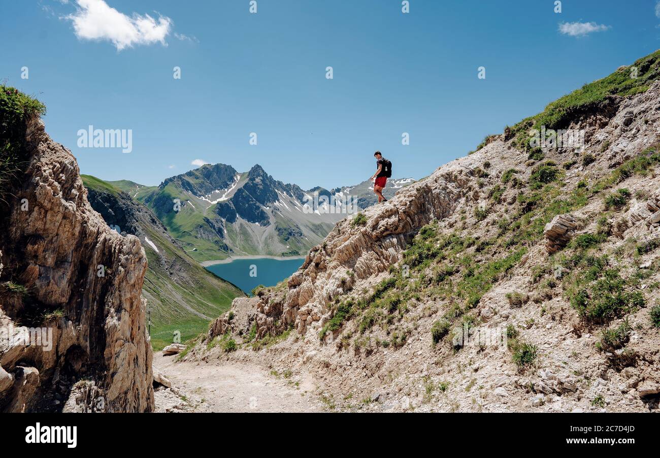Grimpeur avec un sac à dos sur un jour ensoleillé, un homme s'est mis sur la montagne, les gens voyageant à travers la belle nature sauvage. Vacances en paysage Banque D'Images