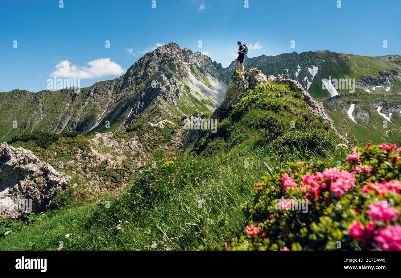 Grimpeur avec un sac à dos sur un jour ensoleillé, un homme s'est mis sur la montagne, les gens voyageant à travers la belle nature sauvage. Vacances en paysage Banque D'Images
