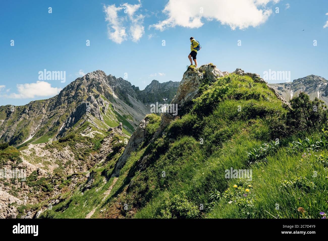 Grimpeur avec un sac à dos sur un jour ensoleillé, un homme s'est mis sur la montagne, les gens voyageant à travers la belle nature sauvage. Vacances en paysage Banque D'Images