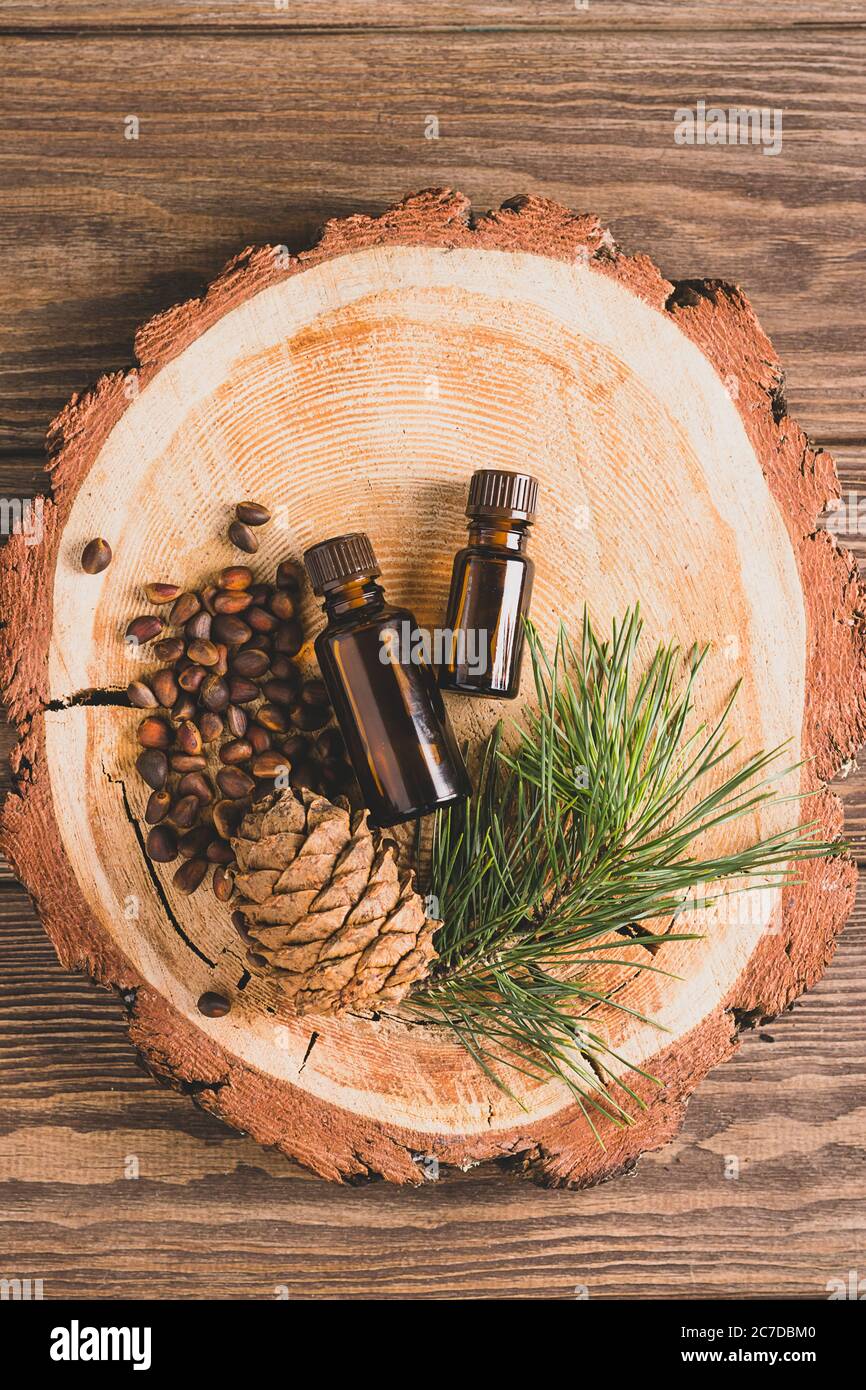 Huile biologique naturelle de pignons de pin dans une bouteille sur fond de bois. Concept pour les cosmétiques naturels et les soins du corps. Banque D'Images