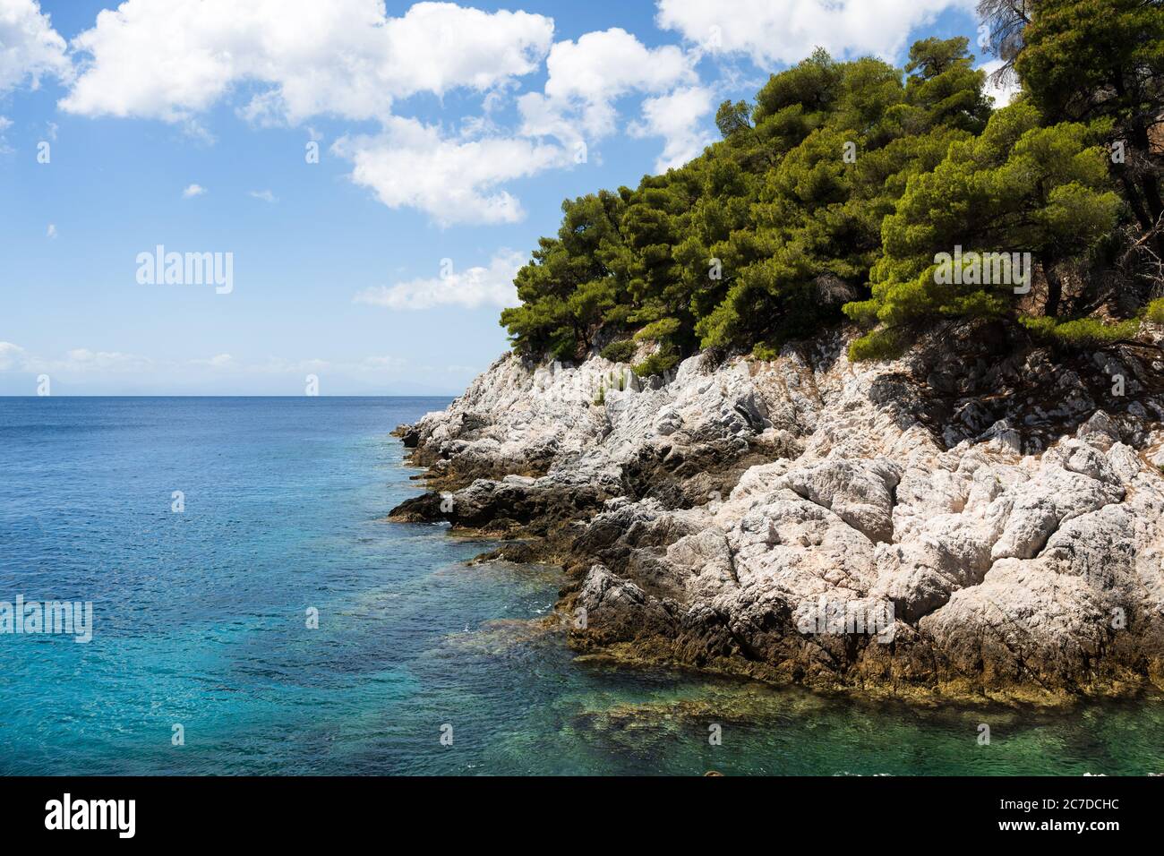 La côte rocheuse blanche avec des arbres et mer bleue calme de l'île grecque de Skopelos des Sporades. Banque D'Images