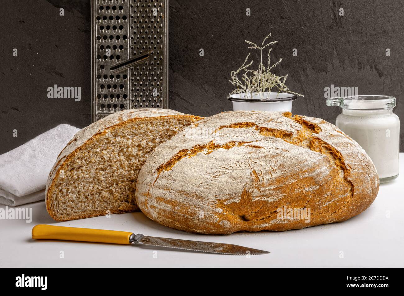 Pain artisanal de levain frais avec entrée de levain sur un comptoir de cuisine Banque D'Images