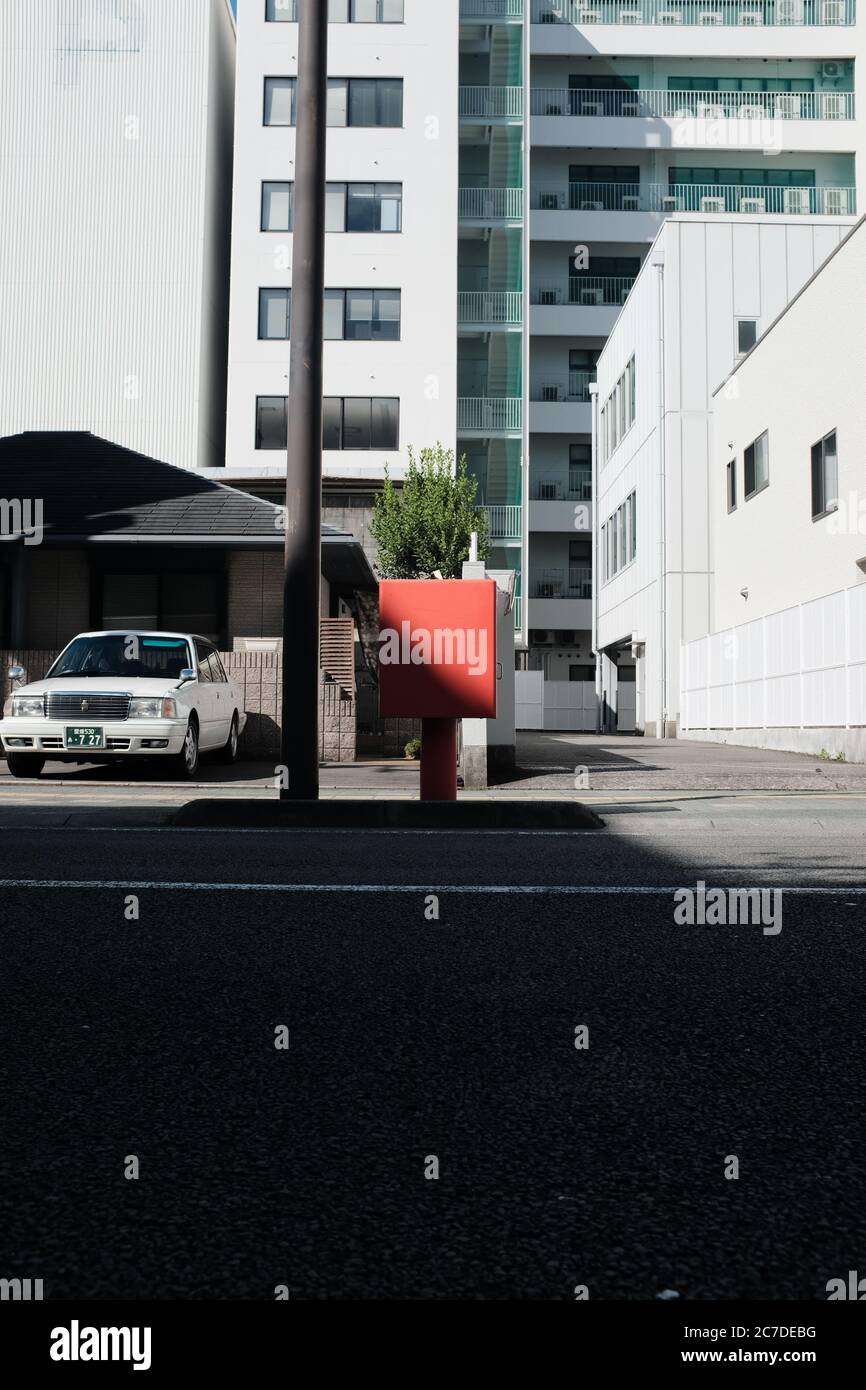 MATSUYAMA, JAPON - 23 septembre 2019 : une photo verticale d'une voiture blanche garée dans un garage près de bâtiments blancs Banque D'Images