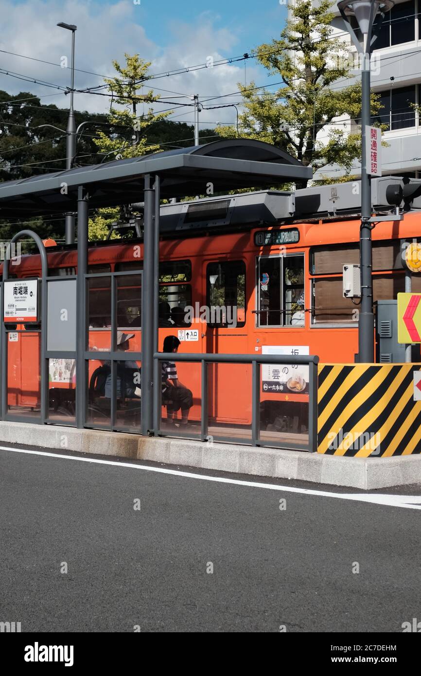MATSUYAMA, JAPON - 23 septembre 2019 : un cliché vertical d'un bus orange à un arrêt de bus Banque D'Images