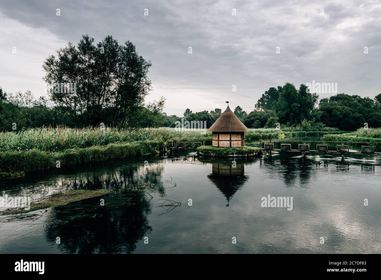 Pièges à anguilles et petite cabane de pêche au chaume sur la rivière Test, près du village de Longstock, Hampshire (Hants), Angleterre, Royaume-Uni Banque D'Images