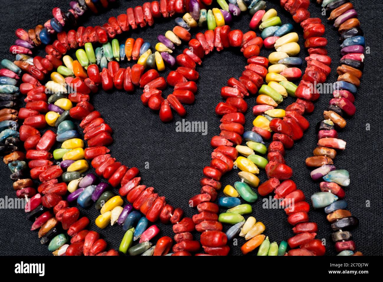 Des bonbons colorés en forme de coeur arc-en-ciel sur fond noir. Banque D'Images