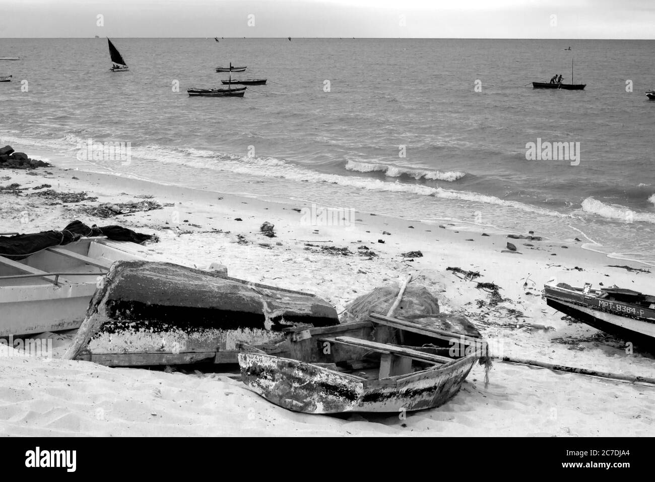 Boutres altérés sur la plage de sable dans un petit port de pêche à Maputo, Mozambique, tôt le matin, photographiés en monochrome Banque D'Images