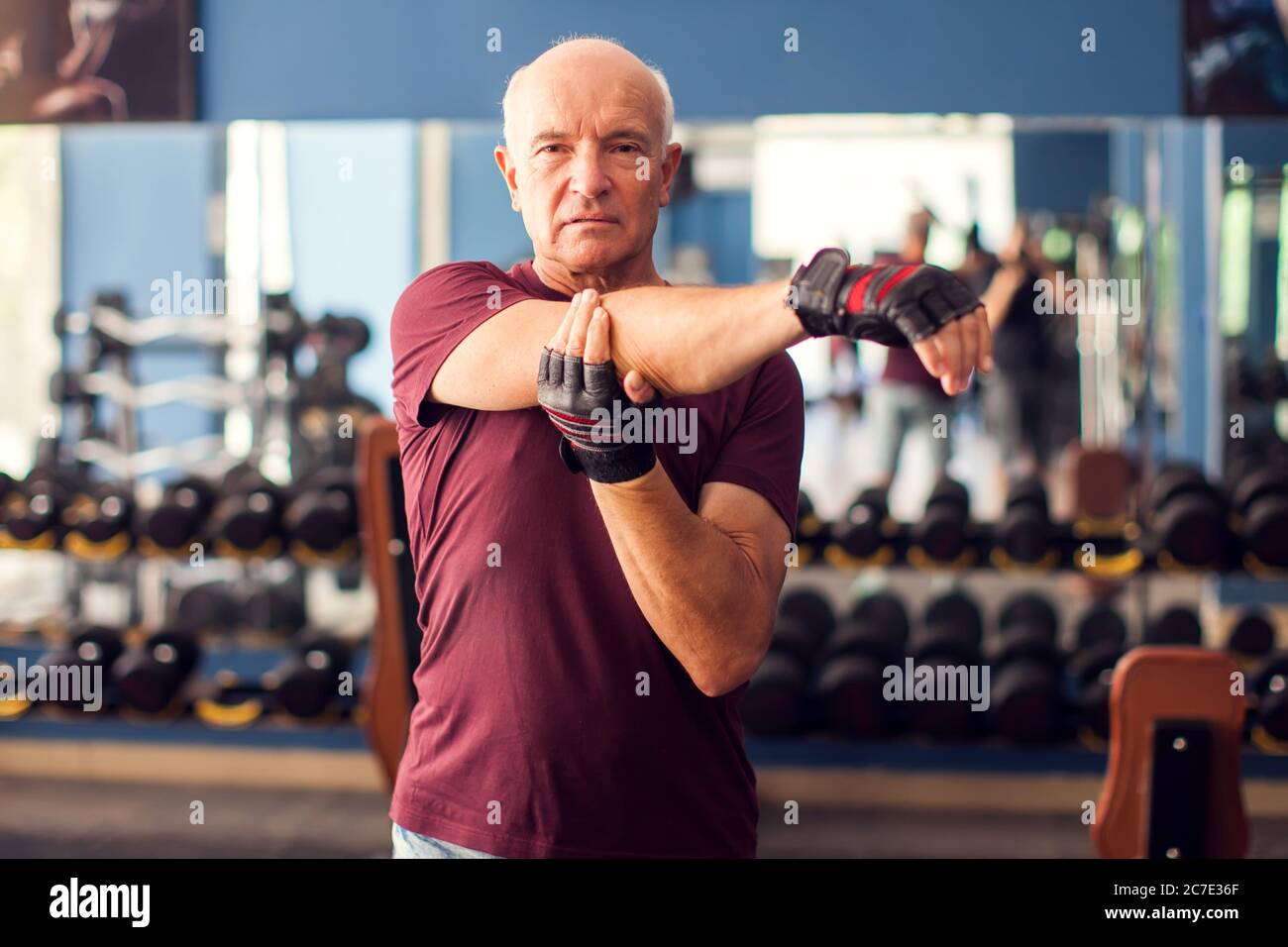 Un portrait d'homme âgé chauve qui fait de l'exercice avant de s'entraîner dans la salle de gym. Concept de personnes, de soins de santé et de mode de vie Banque D'Images