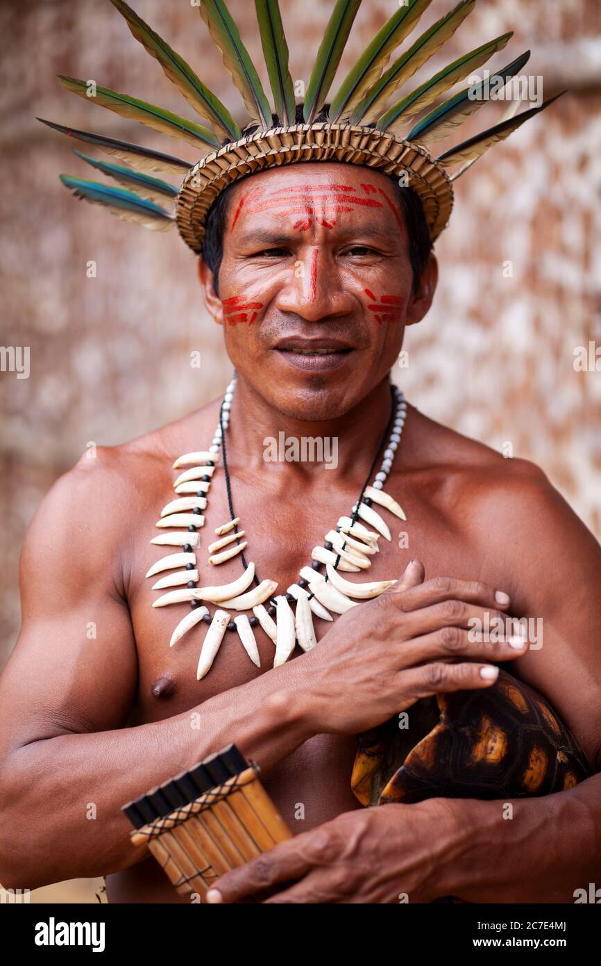 Homme indigène avec une couronne de plumes et un tambour de carapace de tortue Banque D'Images