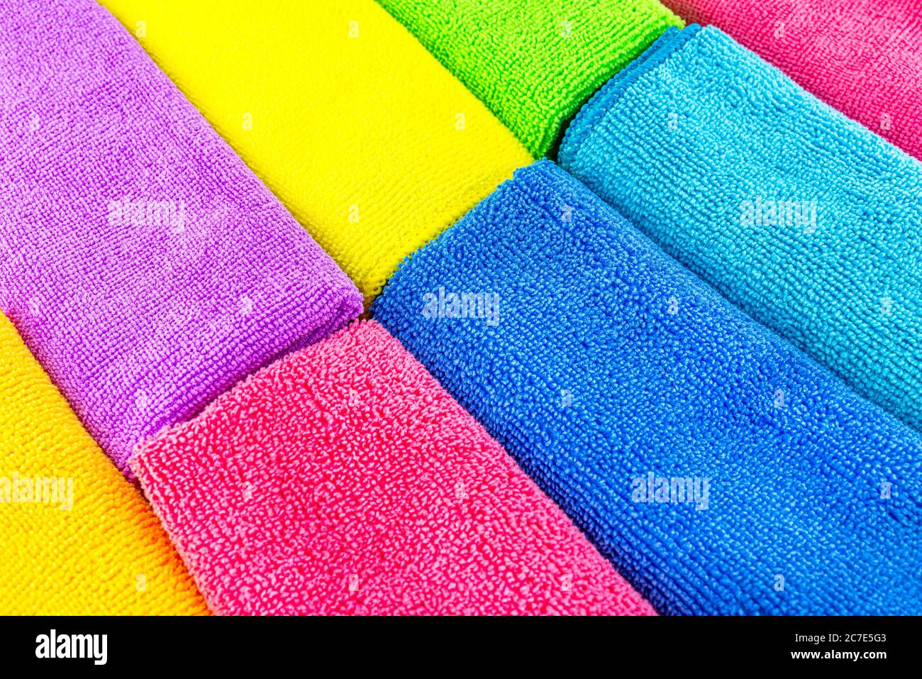 Arrière-plan composé de différentes couleurs de matériau en microfibre empilées côte à côte, vue de dessus. Banque D'Images