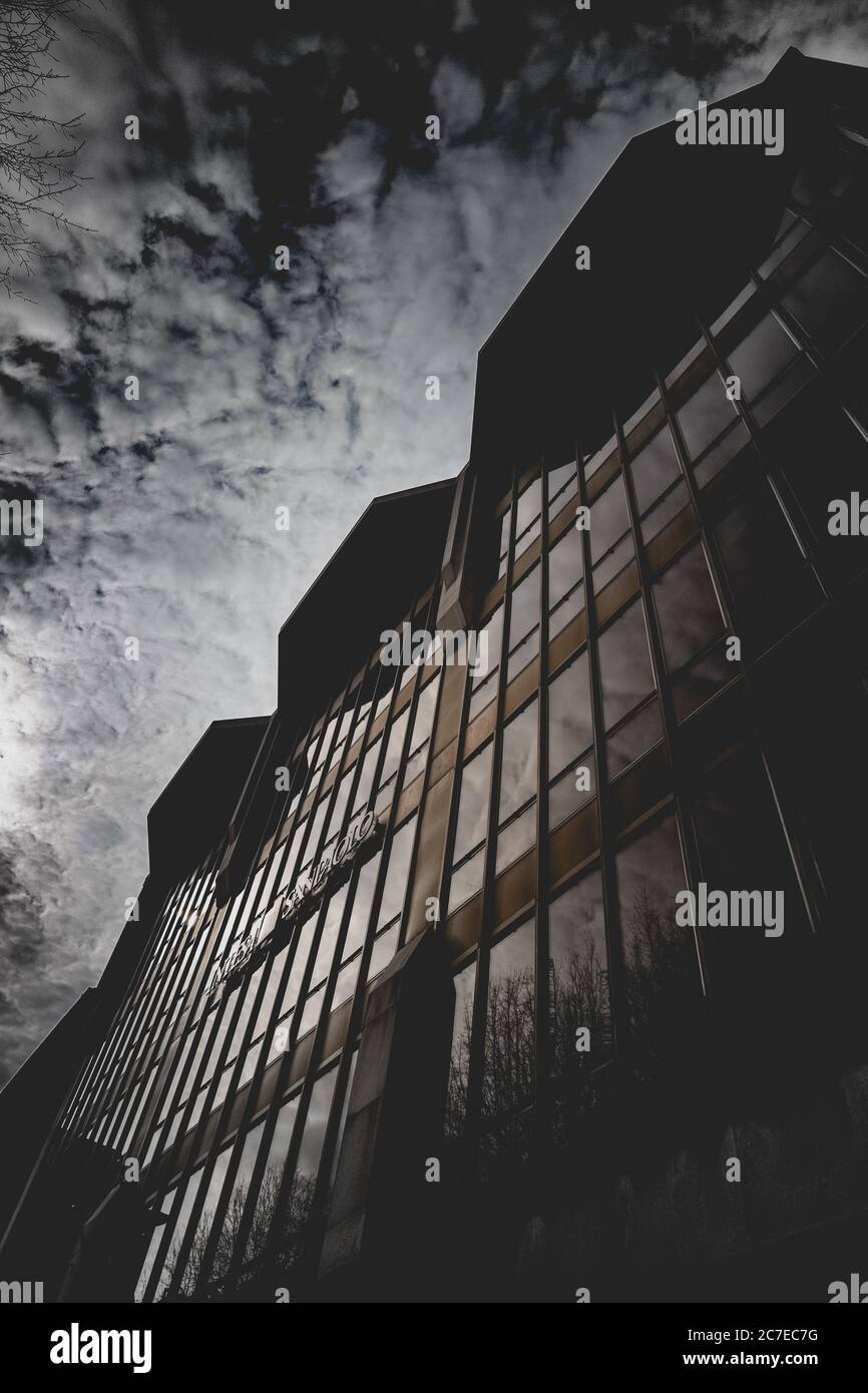 Prise de vue verticale en niveaux de gris de nuages à couper le souffle dans un bâtiment avec glaces à miroir Banque D'Images