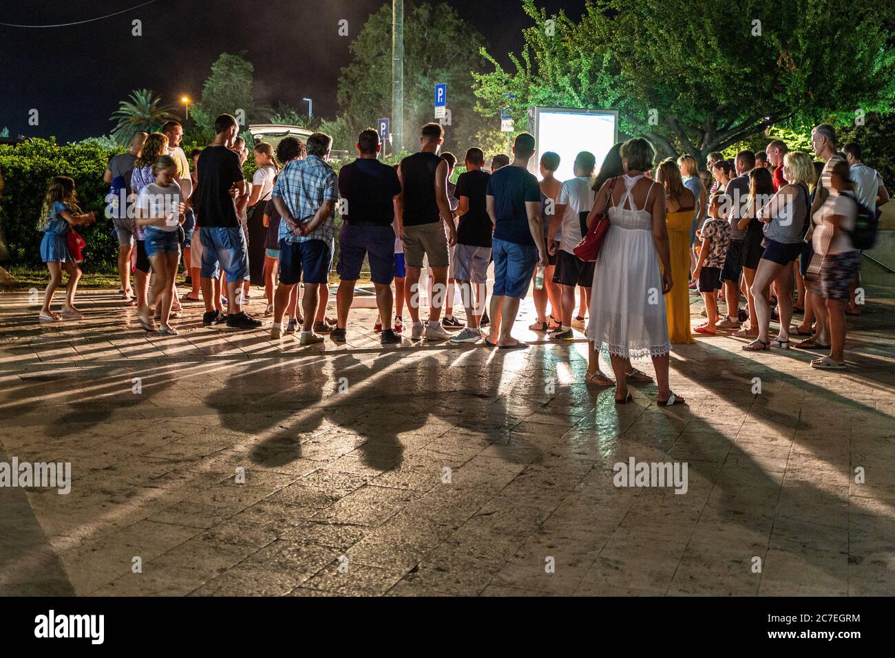 Les spectateurs se rassemblent pour assister à un artiste au travail lors d'une chaude soirée d'été à Zadar, Dalmatie, Croatie Banque D'Images