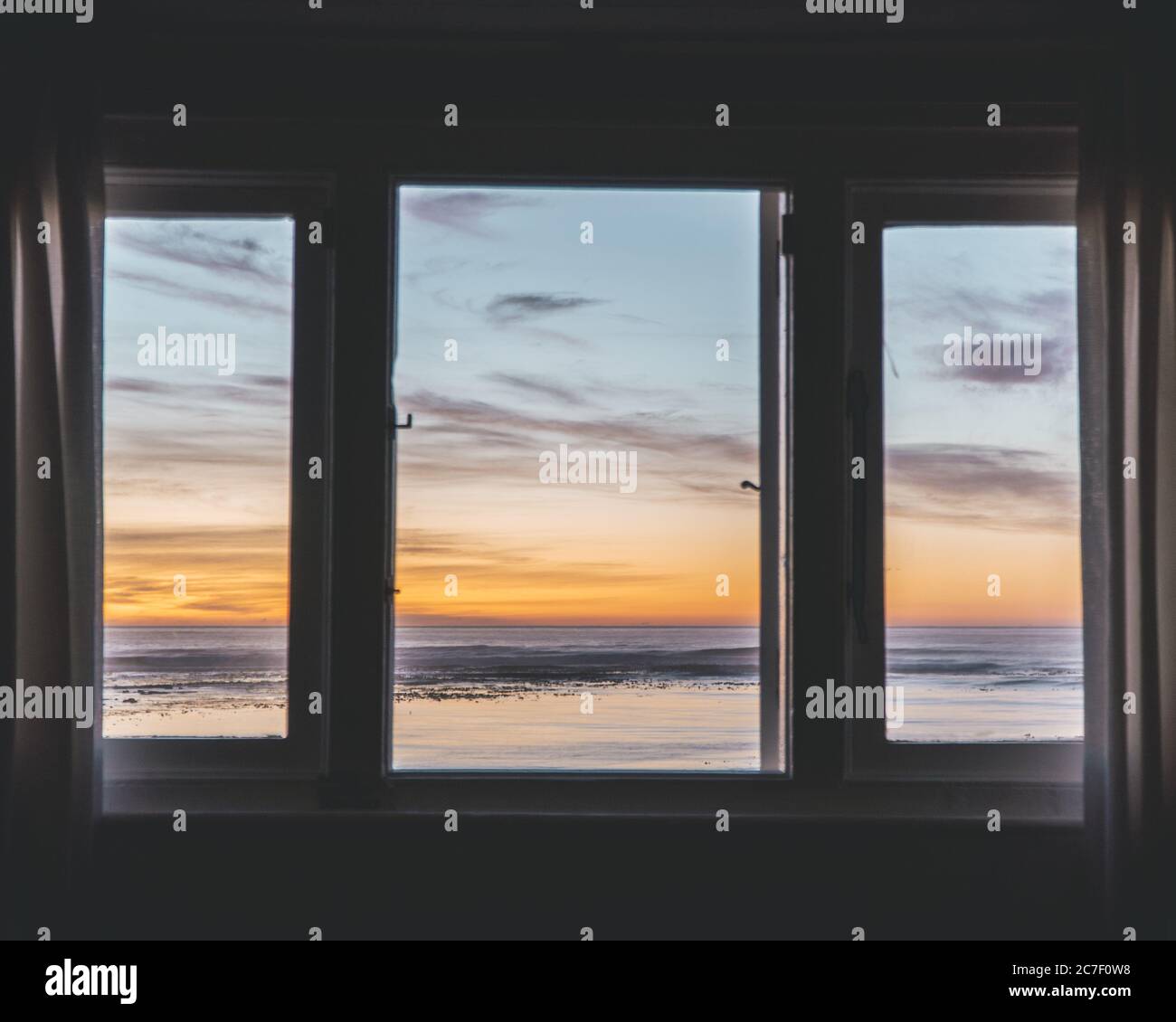 Prise de vue horizontale d'un plan d'eau au coucher du soleil une fenêtre Banque D'Images