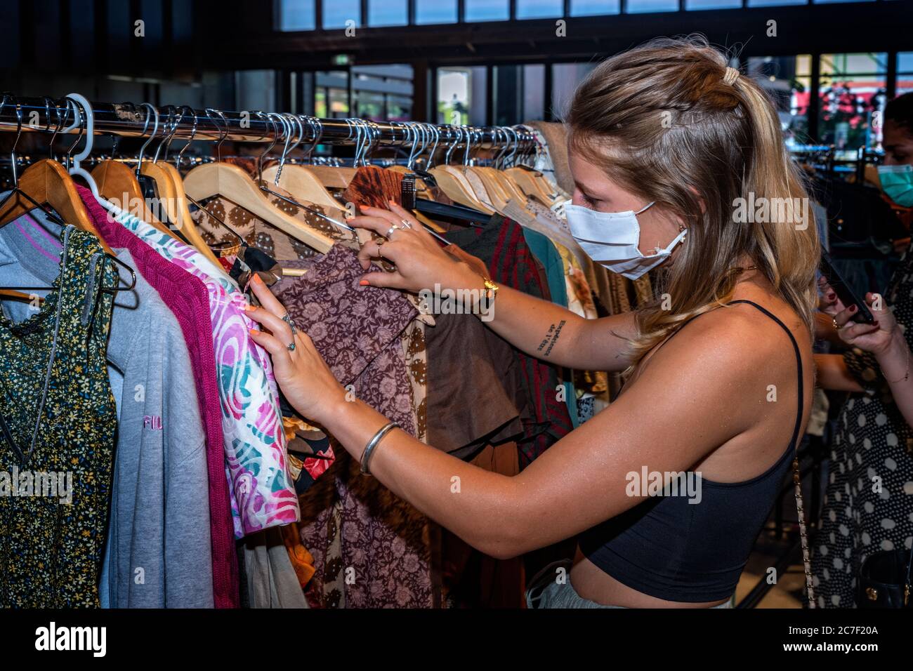 Lyon, Rhône Alpes Auvergne, France Jully 04 2020 : Nouvelle façon de consommer après Covid 19, d'acheter des vêtements au kilo. La femme est lookinng pour les vêtements dans le Banque D'Images Lyon, Rhône Alpes Auvergne, France Jully 04 2020 : Nouvelle façon de consommer après Covid 19, d'acheter des vêtements au kilo. La femme est lookinng pour les vêtements dans le Banque D'Images