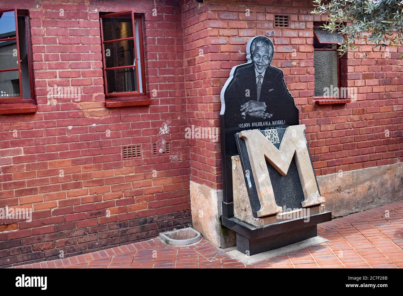 La Maison Mandela sur la rue Vilakazi à Orlando Ouest, Soweto, Johannesburg. Une photo de Nelson Mandela avec un grand M à l'extérieur de la maison en briques rouges. Banque D'Images