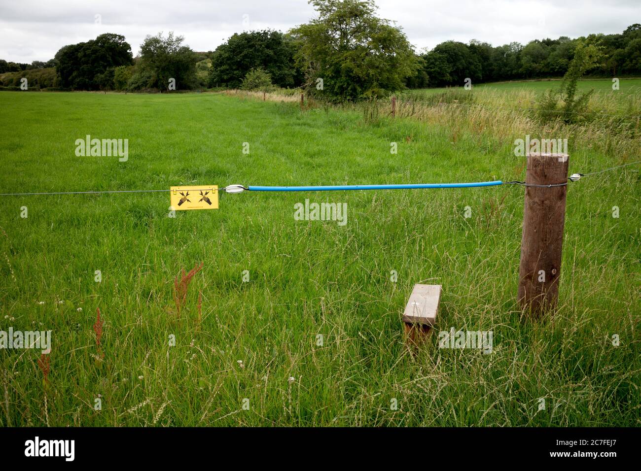 Une clôture électrique dans les terres agricoles avec isolation pour les marcheurs sur un sentier public, Warwickshire, Royaume-Uni Banque D'Images