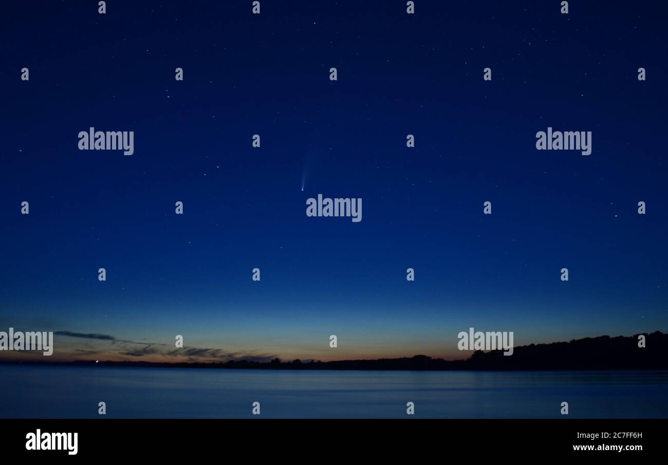 Vue sur un lac à minuit avec la comète Neowise dans le ciel Banque D'Images