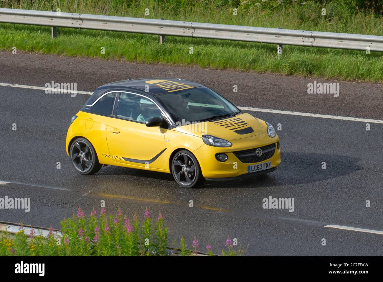 2014 jaune Vauxhall Adam Slam; véhicules routiers, voitures roulant sur les routes britanniques, moteurs, véhicules motorisés sur le réseau d'autoroute M6. Banque D'Images