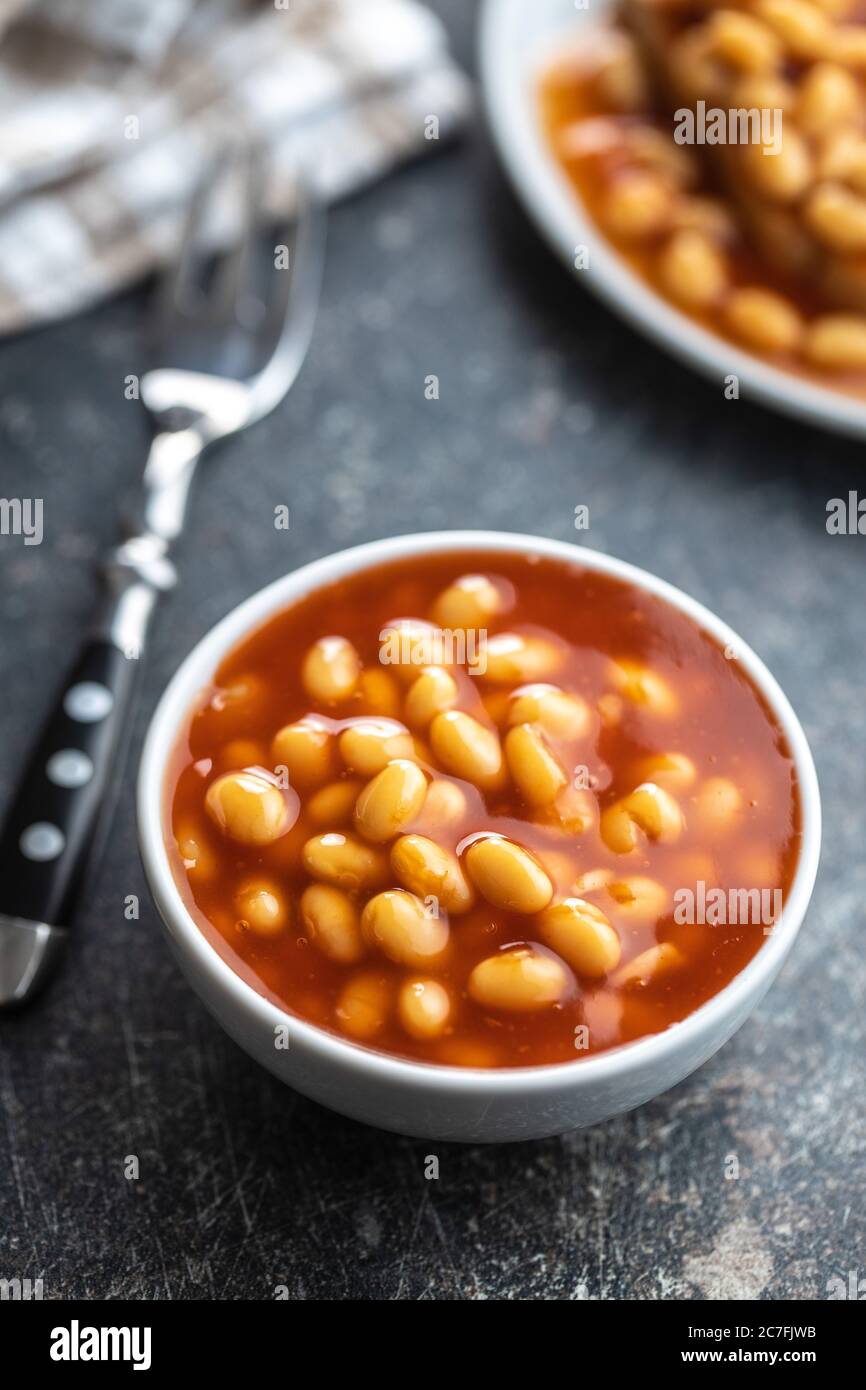 Grains cuits dans un bol. Haricots avec sauce tomate sur la table de cuisine. Banque D'Images
