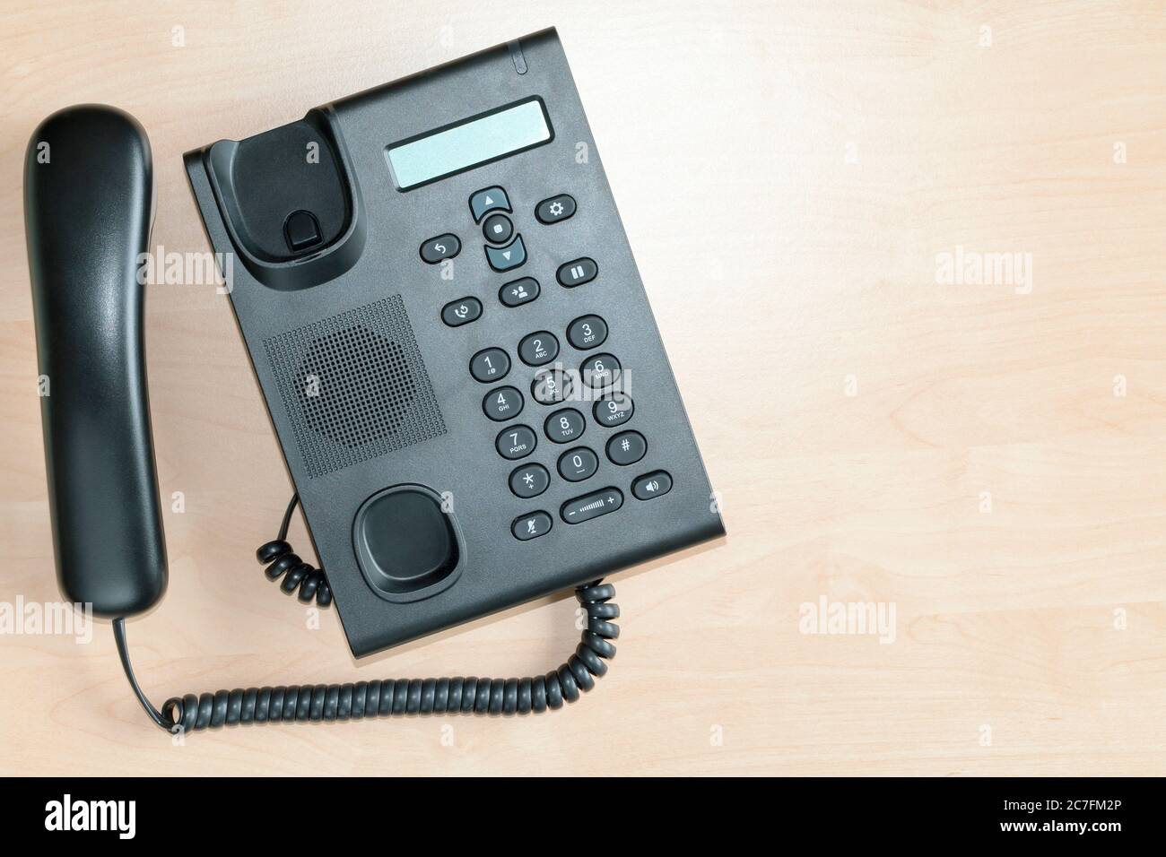 Téléphone VoIP sur un bureau avec le récepteur décroché du plafond avec espace de copie Banque D'Images